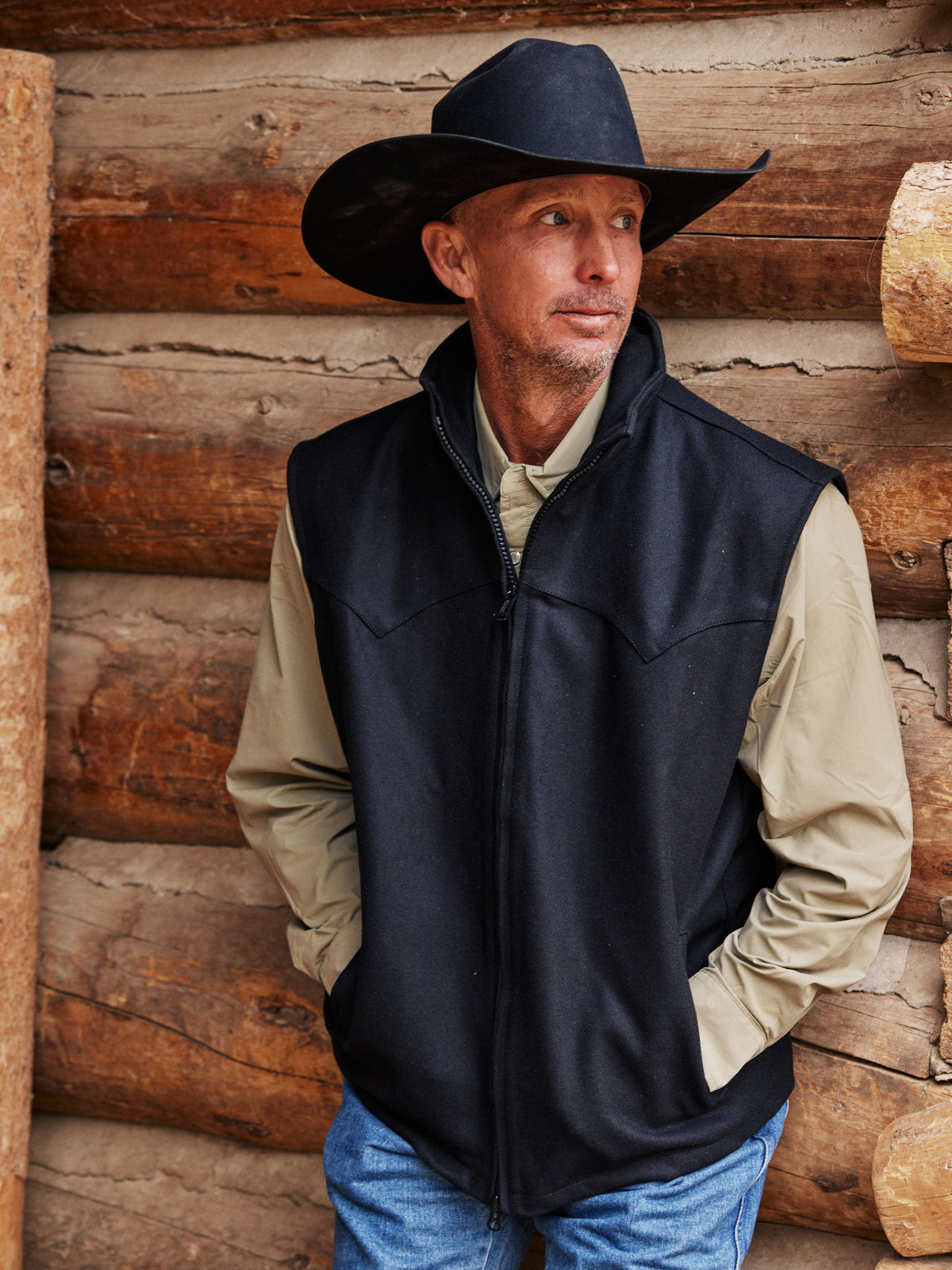Black wool vest worn over a beige shirt with a dark cowboy hat