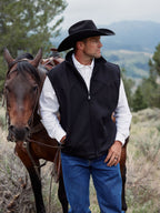 Black wool vest worn over a white shirt and blue jeans