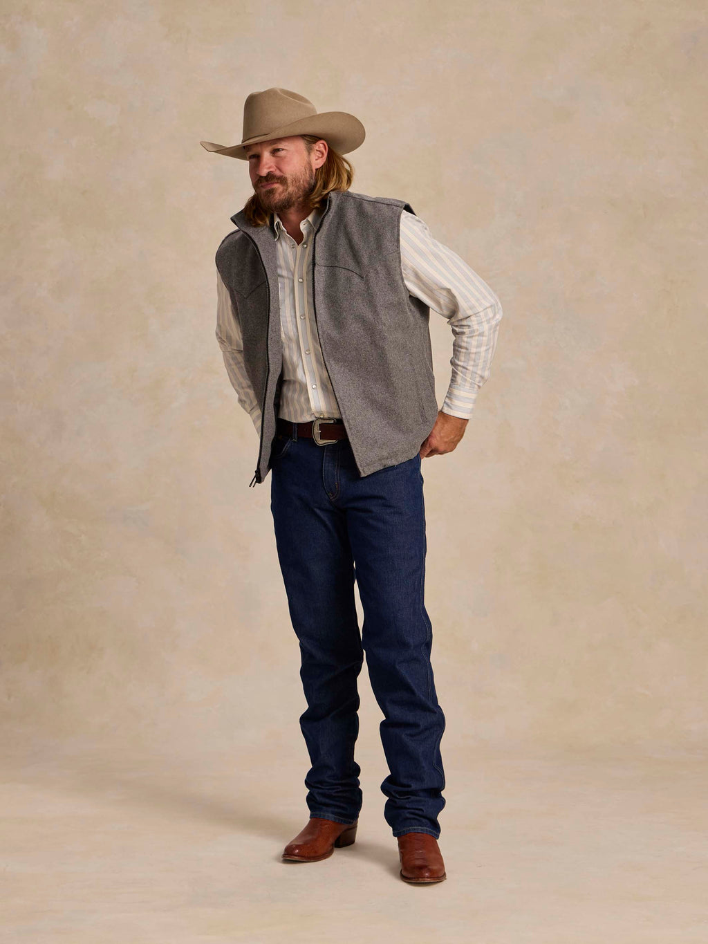 Heather gray sleeveless wool vest with stand collar and full zipper, worn over plaid shirt.