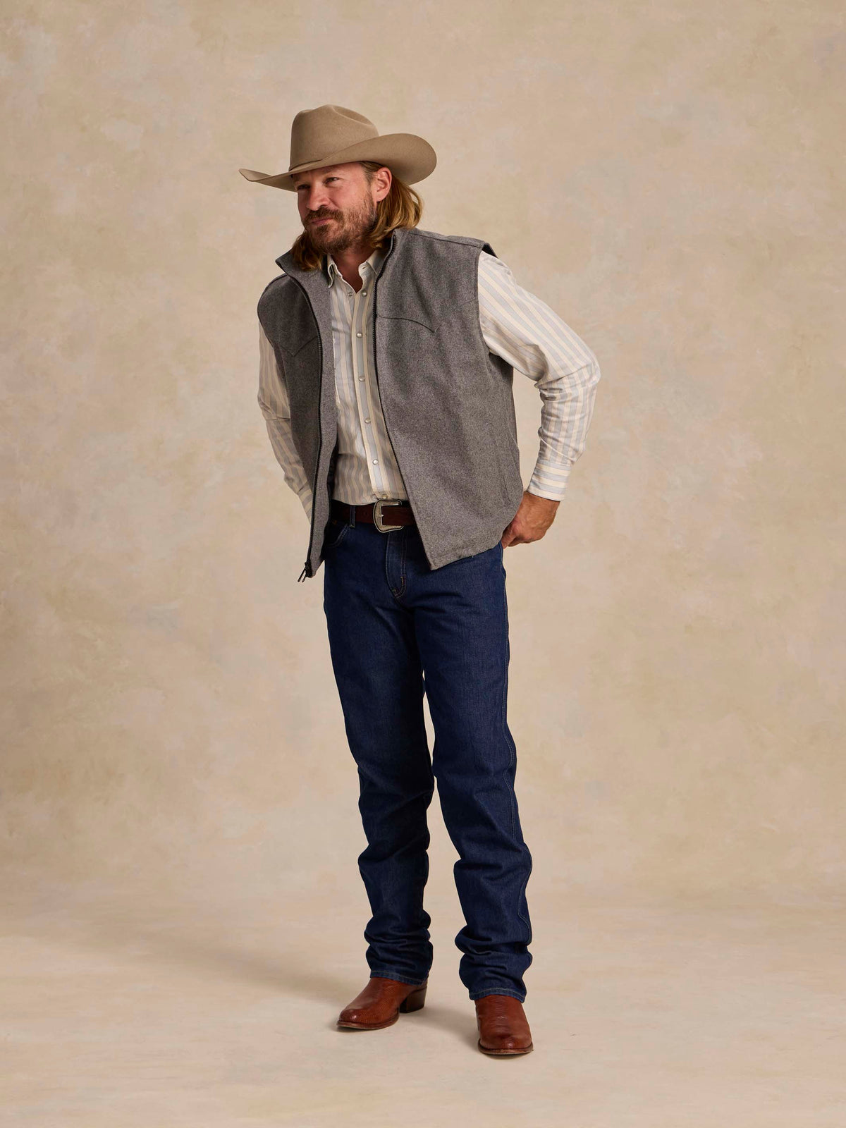 Heather gray sleeveless wool vest with stand collar and full zipper, worn over plaid shirt.