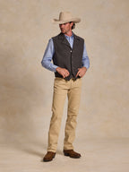 Model wearing charcoal wool vest over a light blue shirt with tan pants