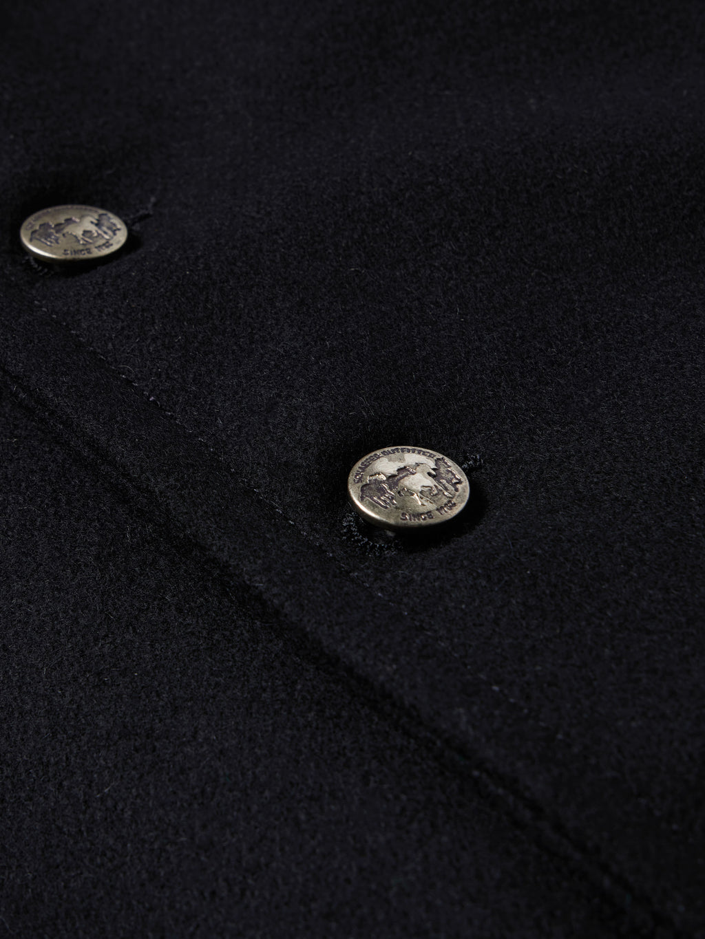 Close-up of black wool vest with oval snap buttons