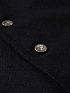 Close-up of black wool vest with oval snap buttons