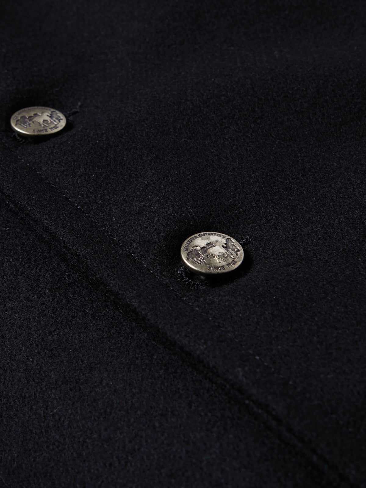 Close-up of black wool vest with oval snap buttons