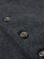 Charcoal wool vest fabric detail with stitched edge and metal button snaps