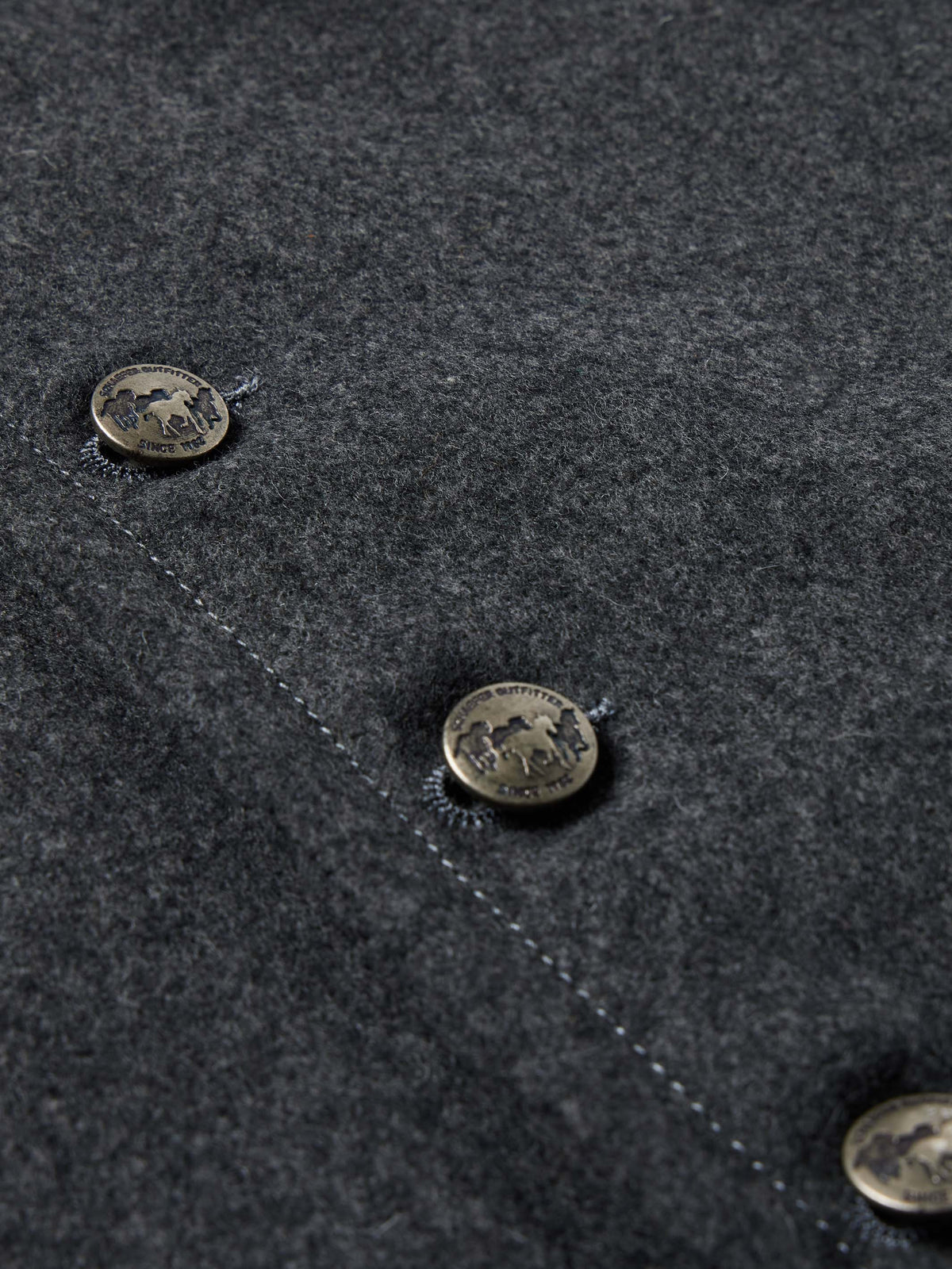 Charcoal wool vest fabric detail with stitched edge and metal button snaps