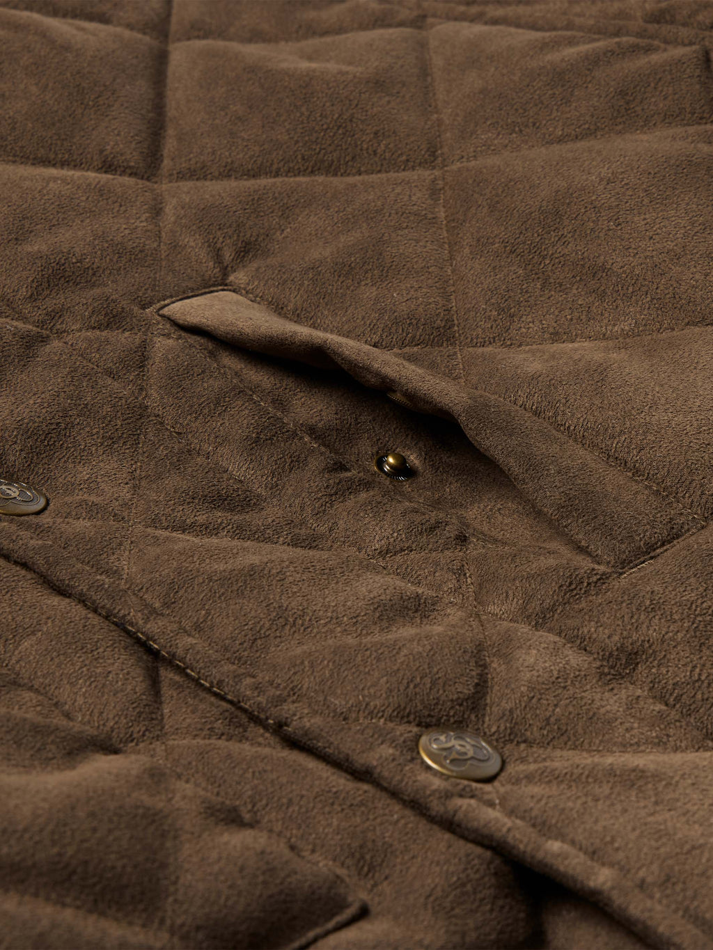 Close-up of brown quilted microsuede jacket with snap buttons on the placket.