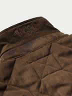 Brown quilted microsuede jacket interior collar lining with embroidered logo patch.