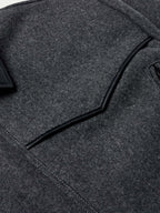 Charcoal wool coat detail: black piping along collar and shoulder panel