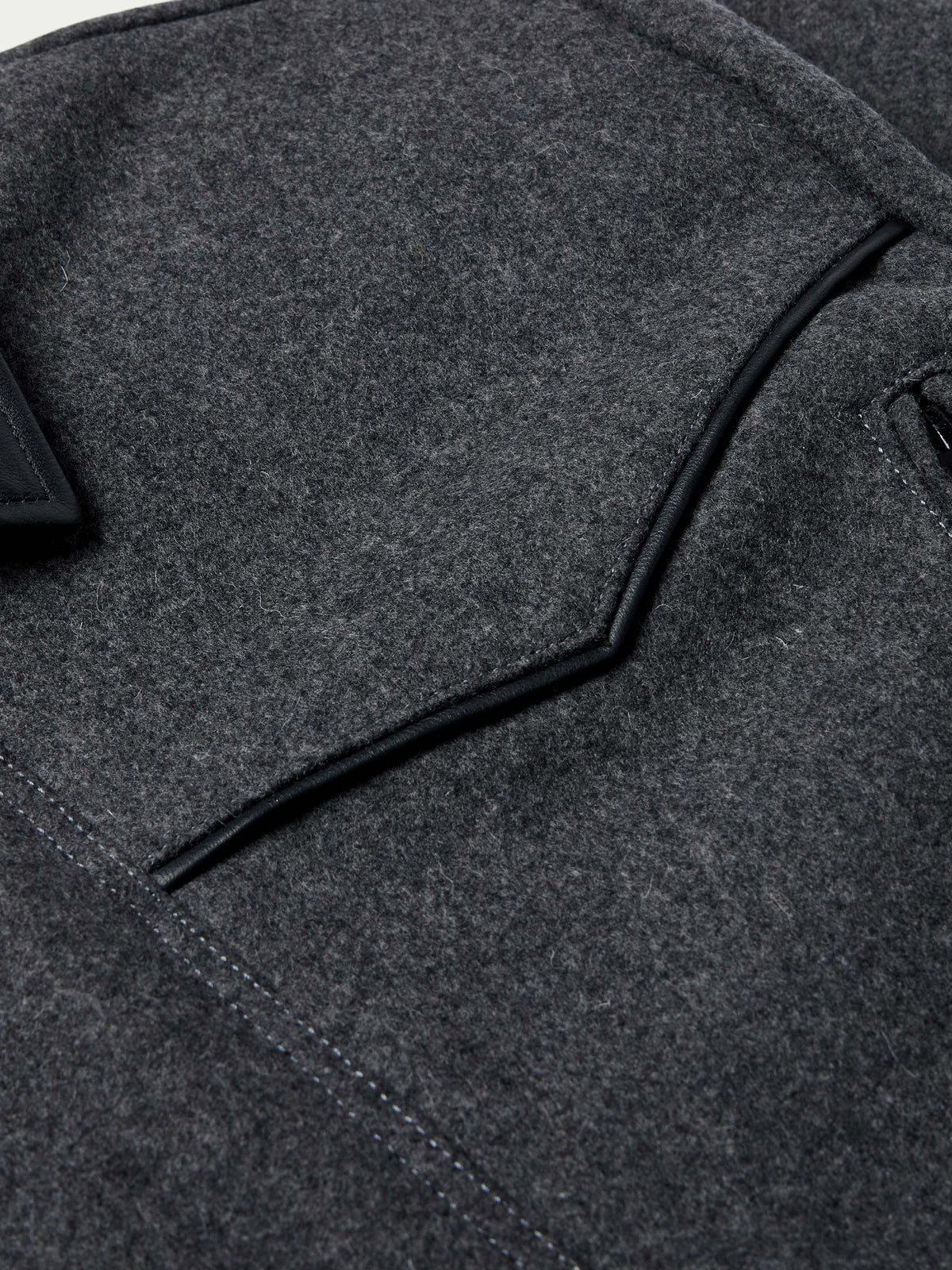 Charcoal wool coat detail: black piping along collar and shoulder panel