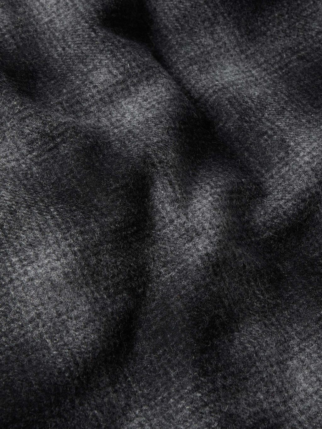 Black wool fabric close-up with soft texture and curved seam lines