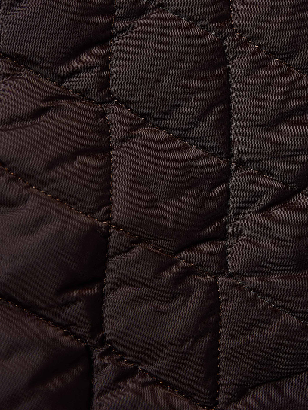 Dark quilted lining detail inside coat with stitched diamond pattern