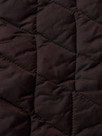 Dark quilted lining detail inside coat with stitched diamond pattern