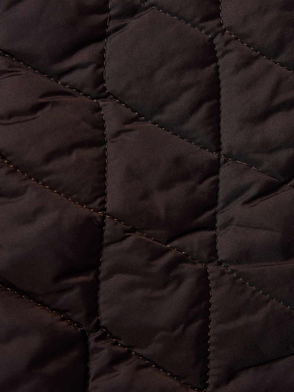 Dark quilted lining detail inside coat with stitched diamond pattern