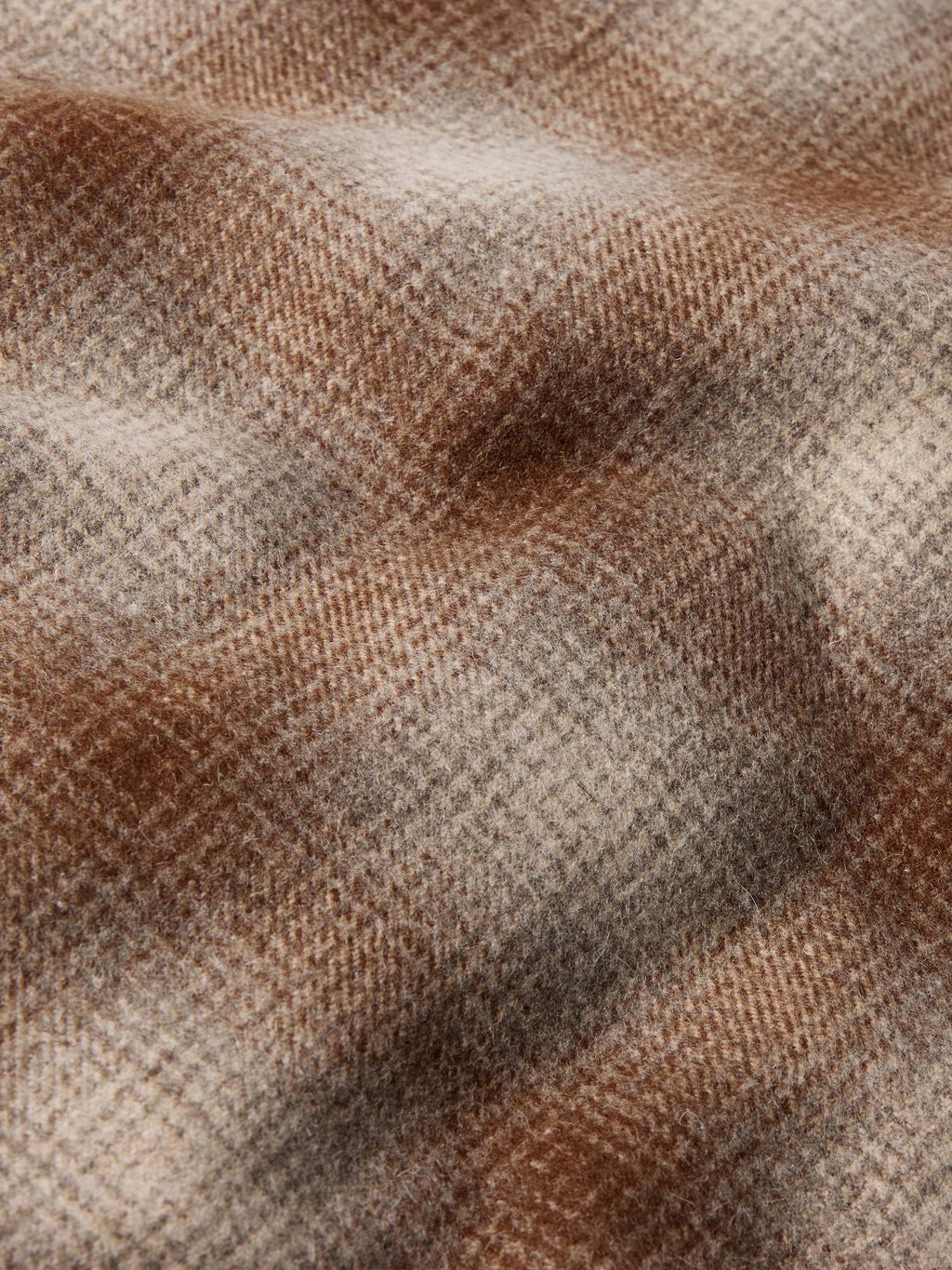 Taupe wool coat fabric close-up with textured weave and plaid pattern