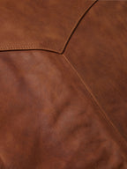 Brown leather vest texture close-up with stitched seam lines