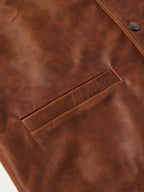 Brown leather vest panel close-up with diagonal yoke seam