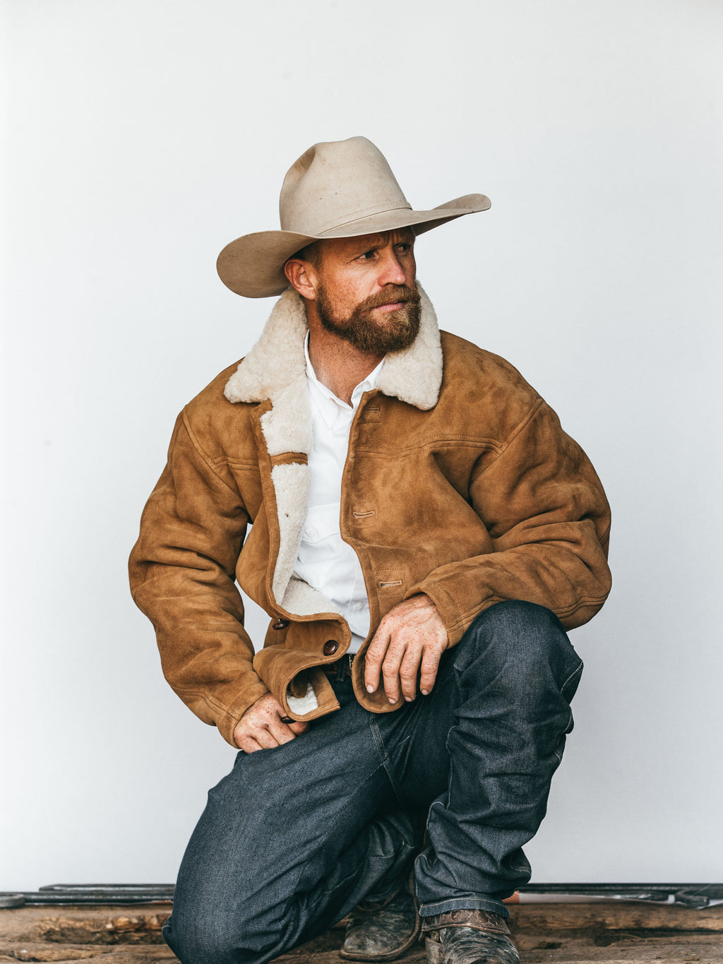 Buckskin shearling coat with white shearling collar, button front, and side pockets
