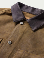 Tan leather jacket with dark collar and snap buttons, front close-up detail.