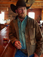 Tan leather brush jacket worn by a man with dark collar and flap pockets.