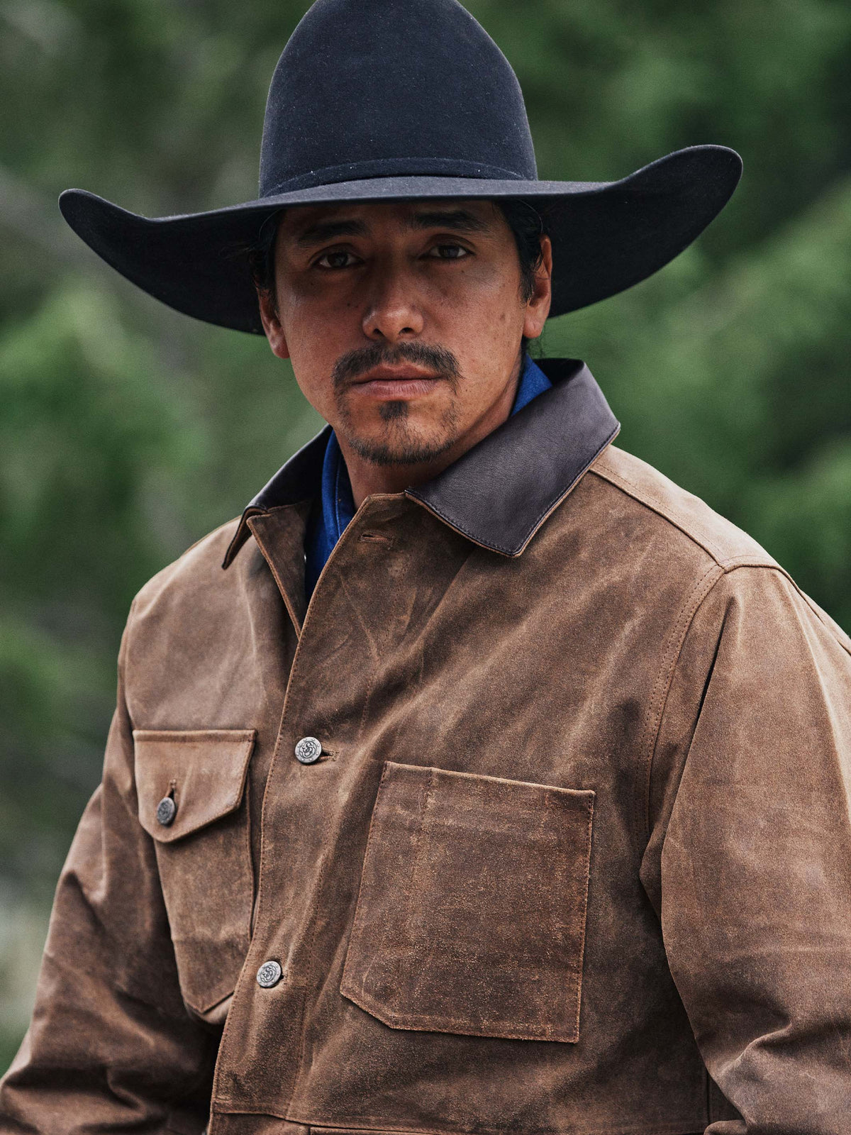 Tan leather jacket front view on a man with dark collar and chest snap pocket.