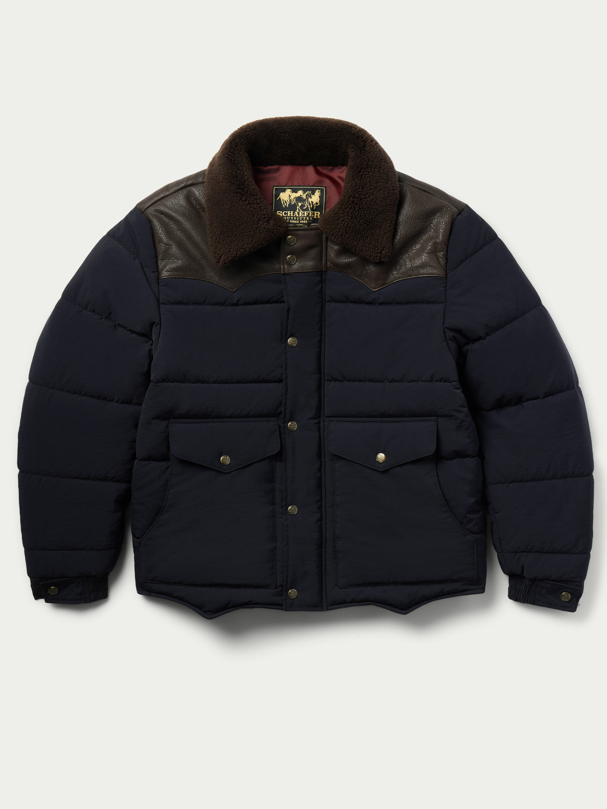 Navy puffer jacket with brown sherpa collar, snap-up front and buttoned chest pockets