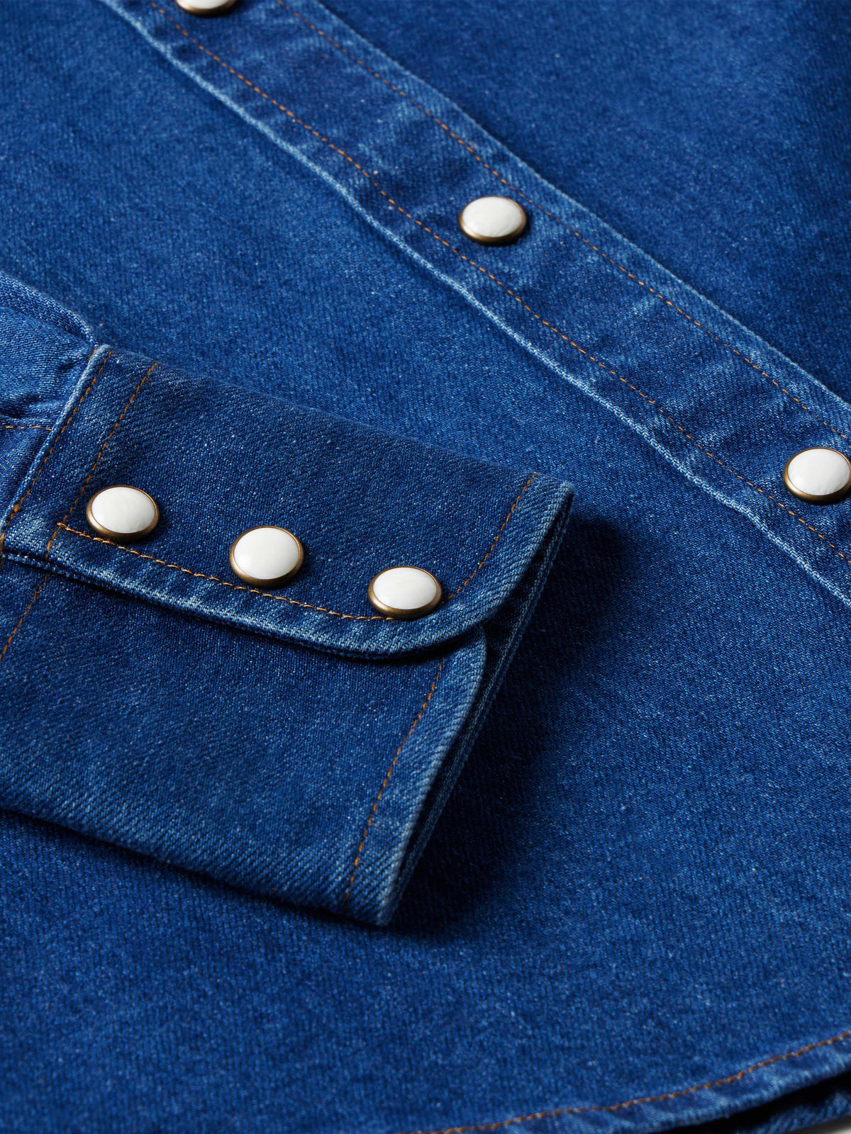 Indigo denim shirt pocket flaps with pearl snaps and contrast stitching