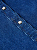 Indigo denim yoke and shoulder seam with pearl snap on sleeve placket