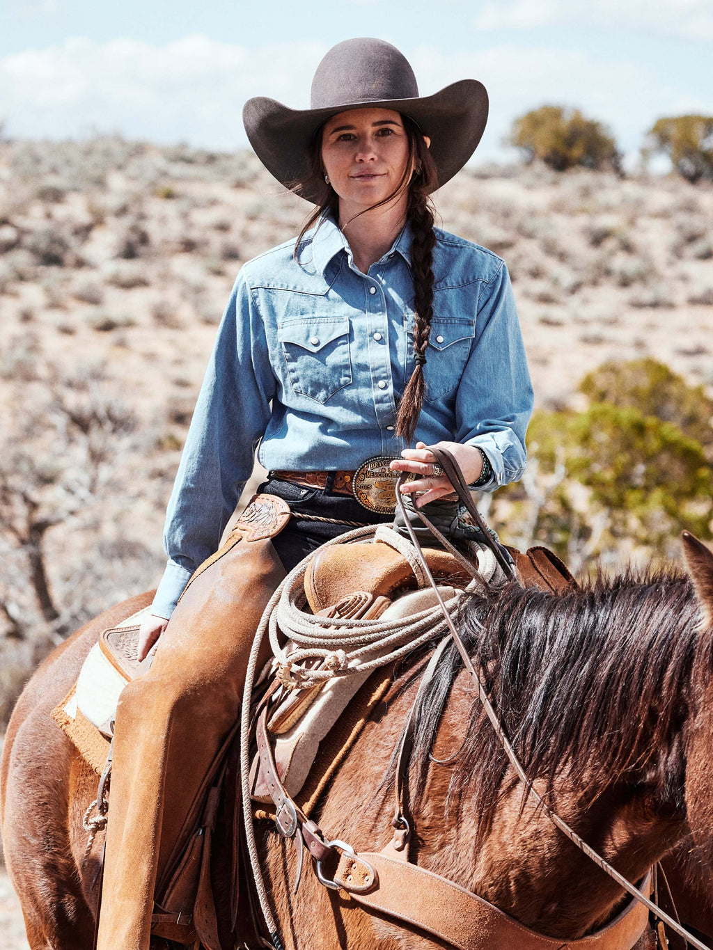 Woman wearing light wash denim pearl snap western shirt with front button placket