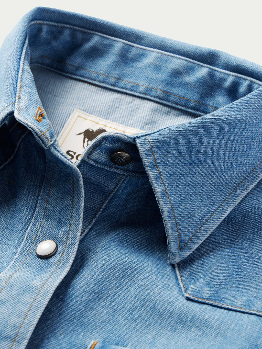 Light wash denim western shirt neckline with pearl snap placket and yoke seam