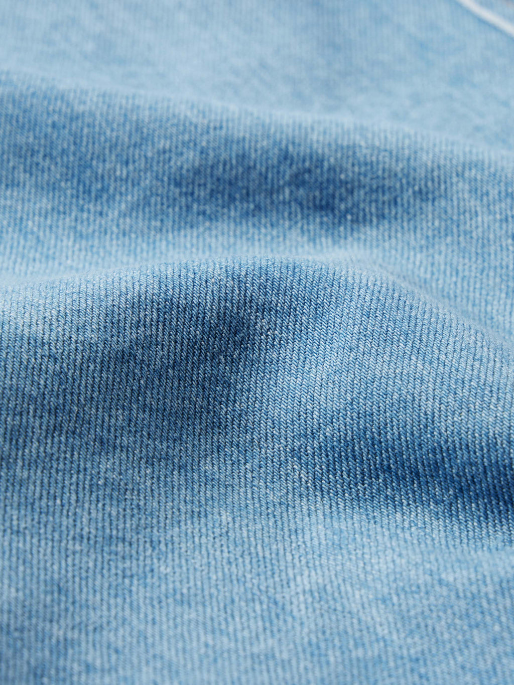 Close-up of light wash denim fabric texture