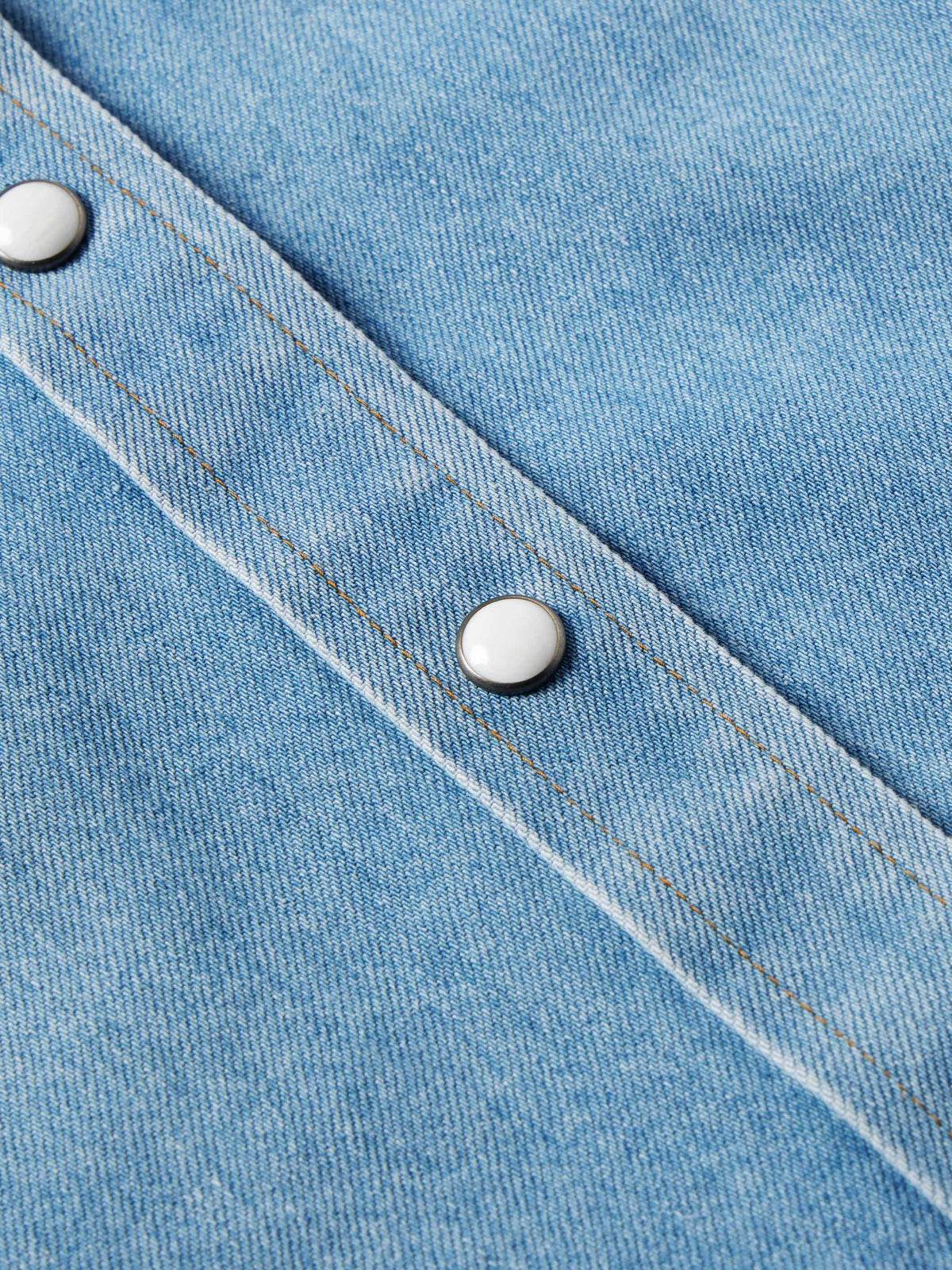Light wash denim western shirt close-up of pearl snap cuff and seam lines