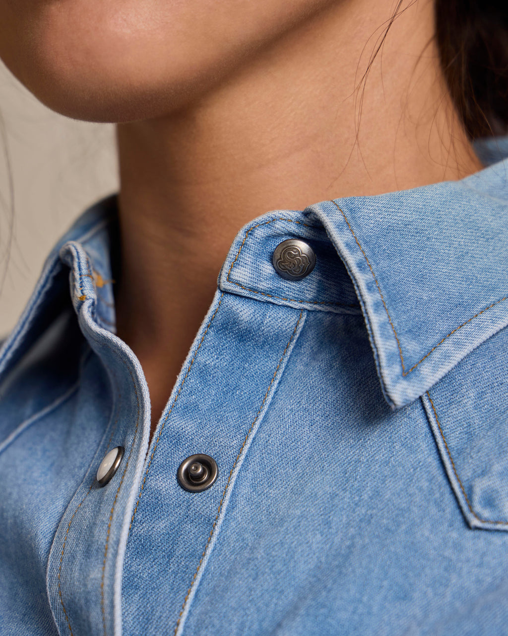 Light wash denim western shirt collar with pearl snap placket and metal buttons