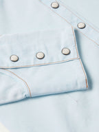 Light wash denim snap shirt chest pocket with metal snaps and curved yoke seam