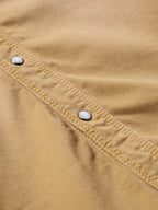 Faded chestnut snap denim shirt fabric close-up with stitched seam and metal snaps