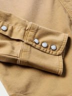 Faded chestnut denim snap shirt sleeve cuff with row of metal snap buttons