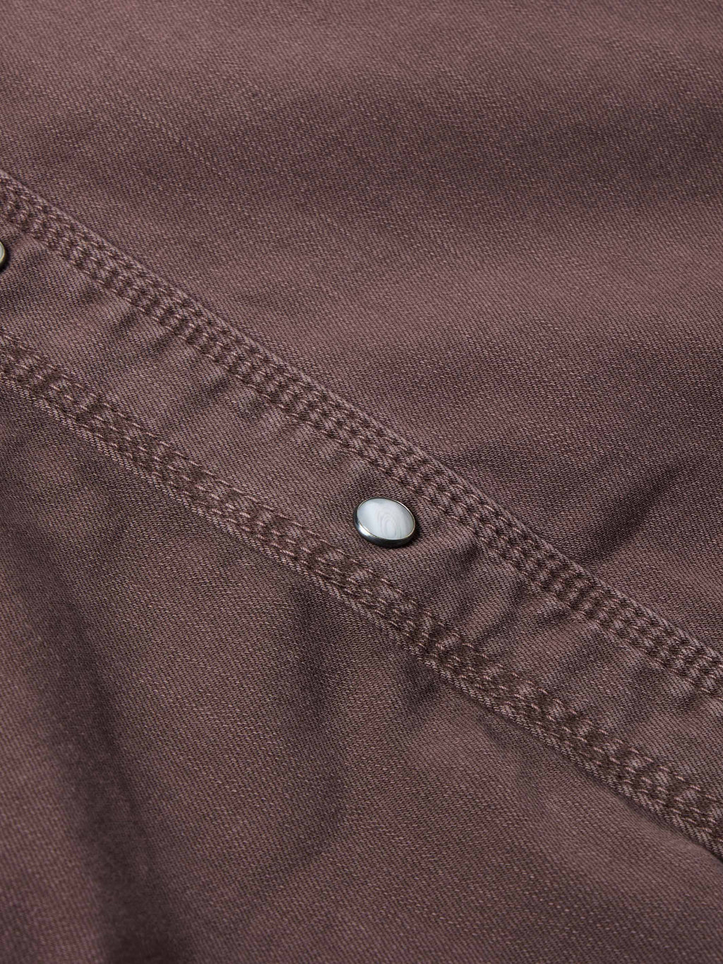 Faded maroon denim snap placket detail with metal snap buttons