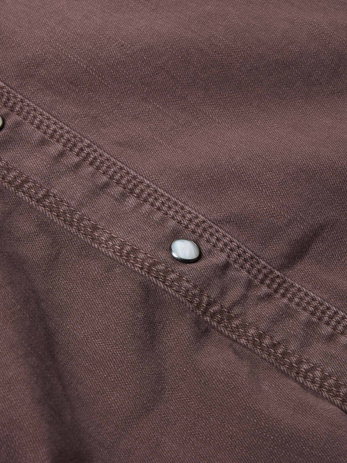 Faded maroon denim snap placket detail with metal snap buttons