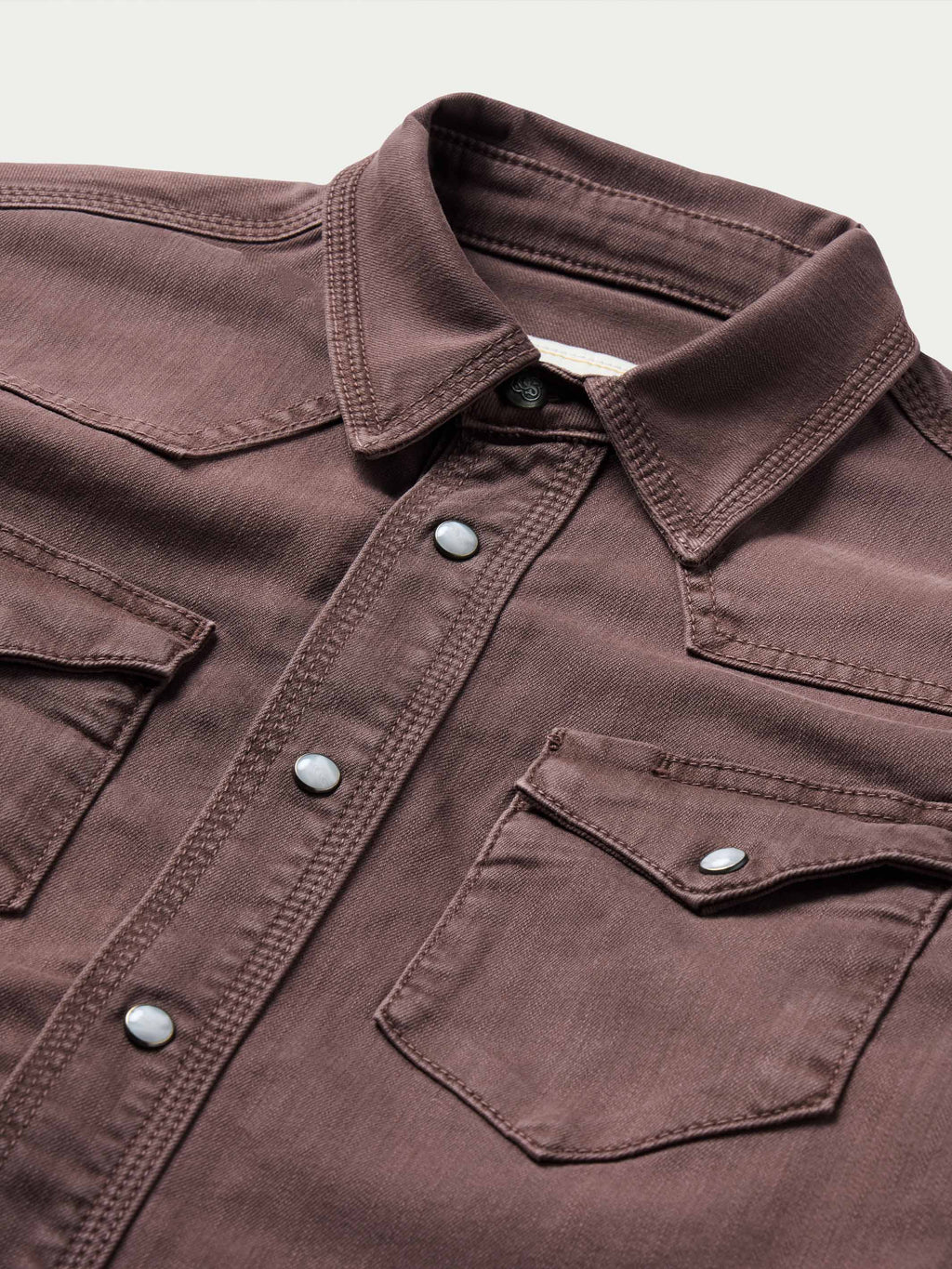 Faded maroon western snap shirt with buttoned chest pockets and collared neckline
