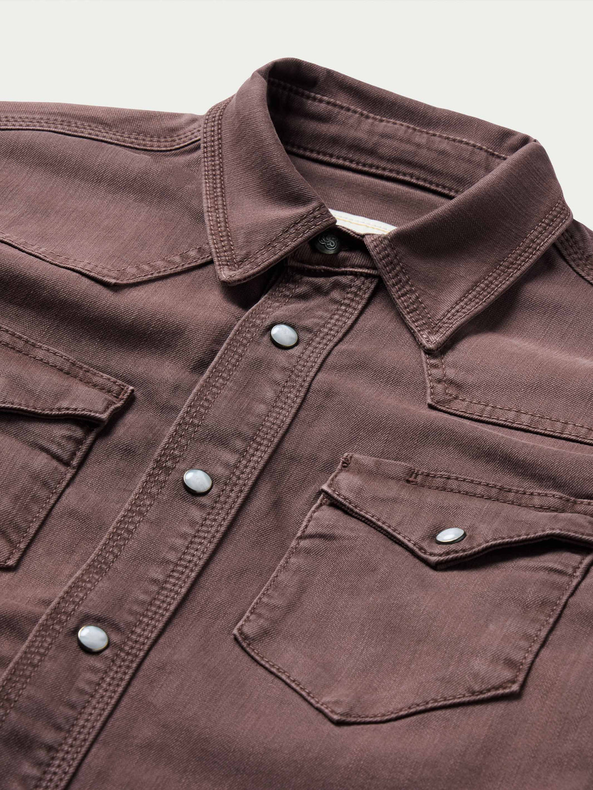 Faded maroon western snap shirt with buttoned chest pockets and collared neckline
