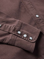 Faded maroon denim snap cuff detail with metal buttons