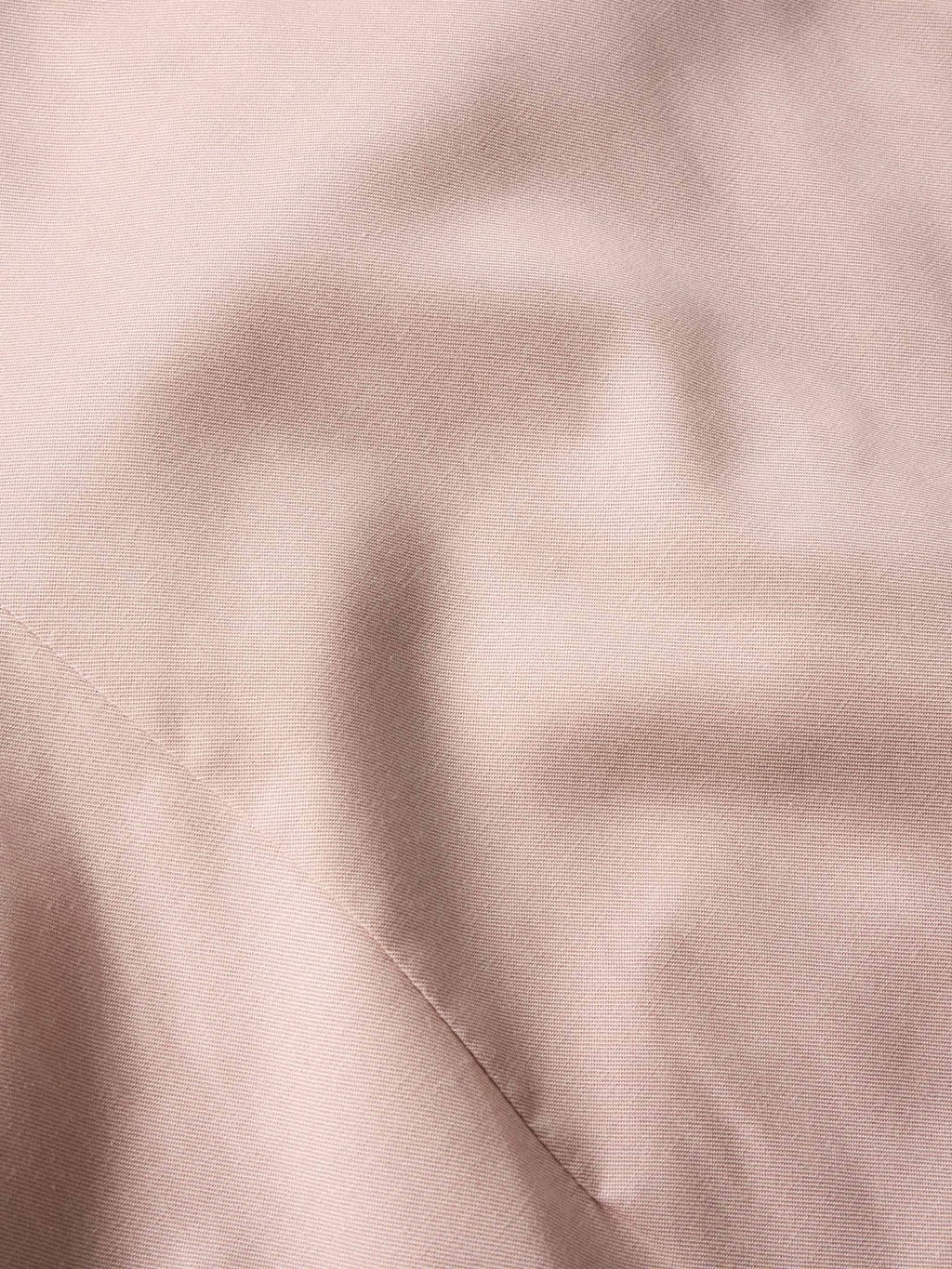 Desert rose fabric close-up of embroidered snap shirt texture and stitching