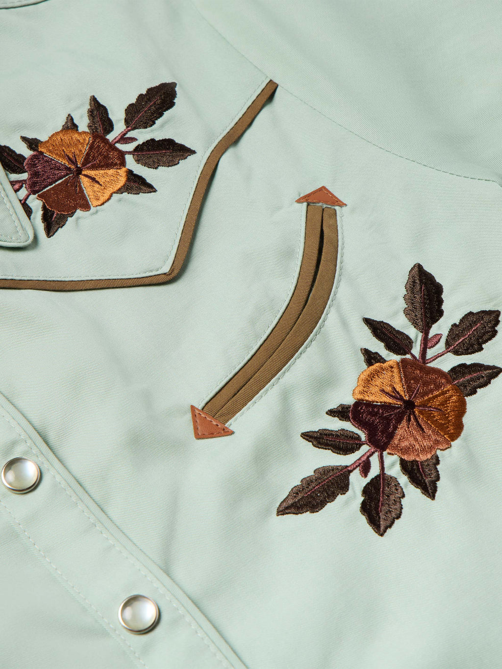 Mint jade snap shirt detail with embroidered floral patches and curved pocket seams