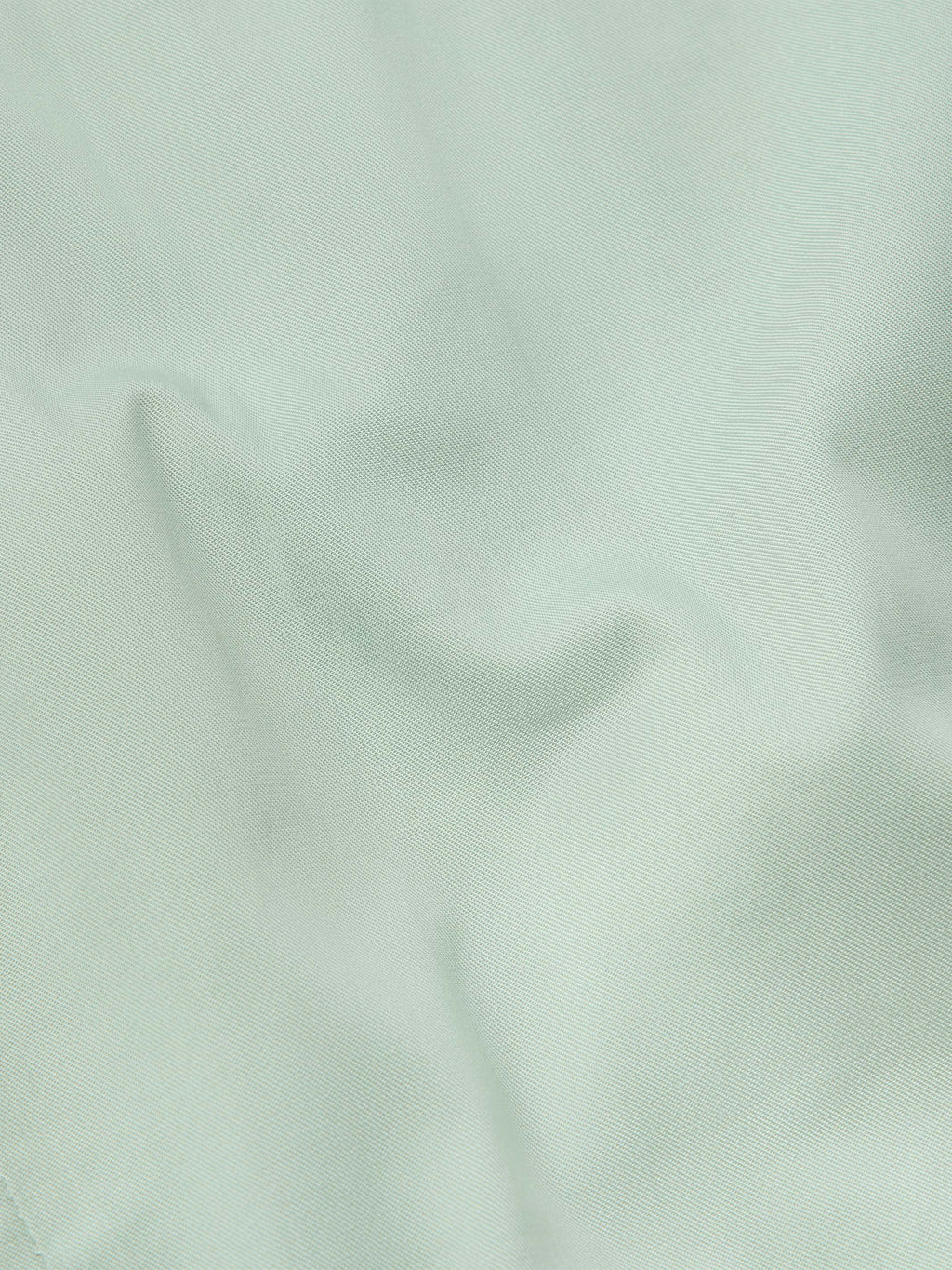 Jade shirt fabric close-up with smooth weave texture