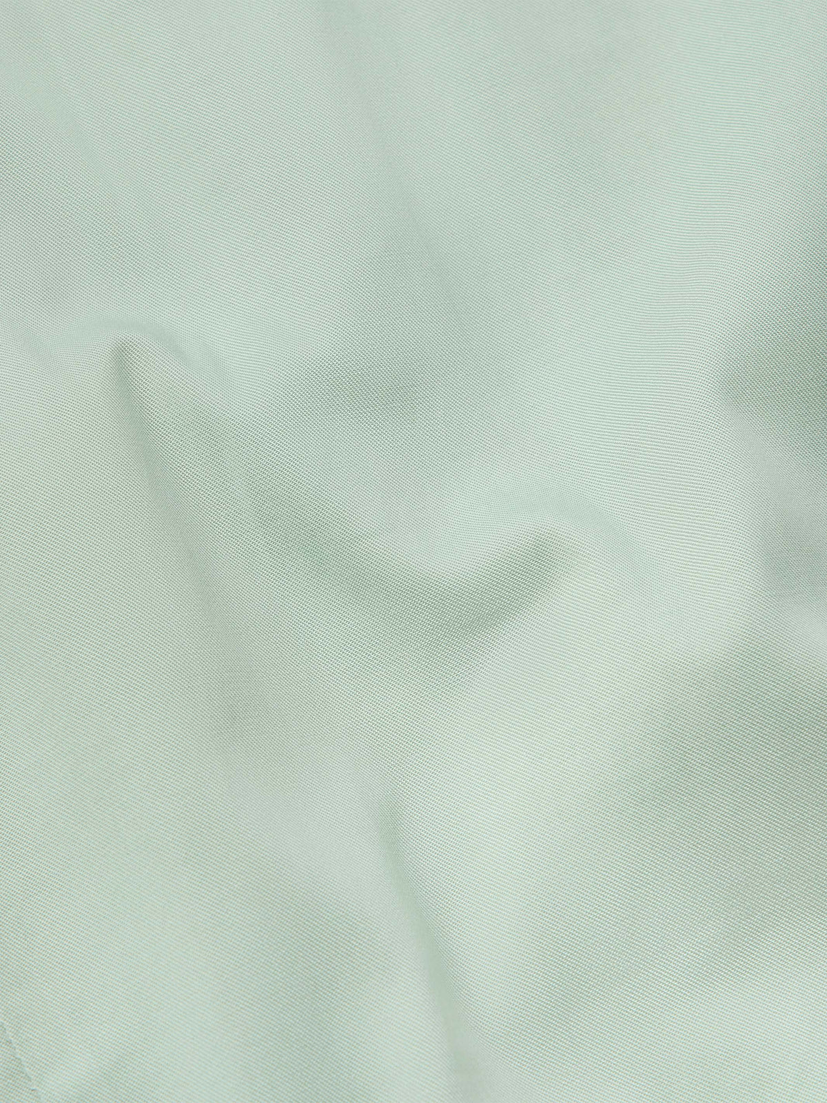 Jade shirt fabric close-up with smooth weave texture