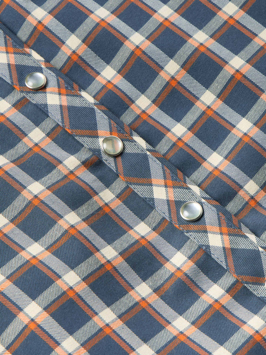 Women’s embroidered snap shirt close-up, sleeve cuff with snap buttons and plaid