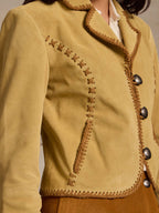 Buttercream suede jacket front with whipstitch seams and metallic button closures