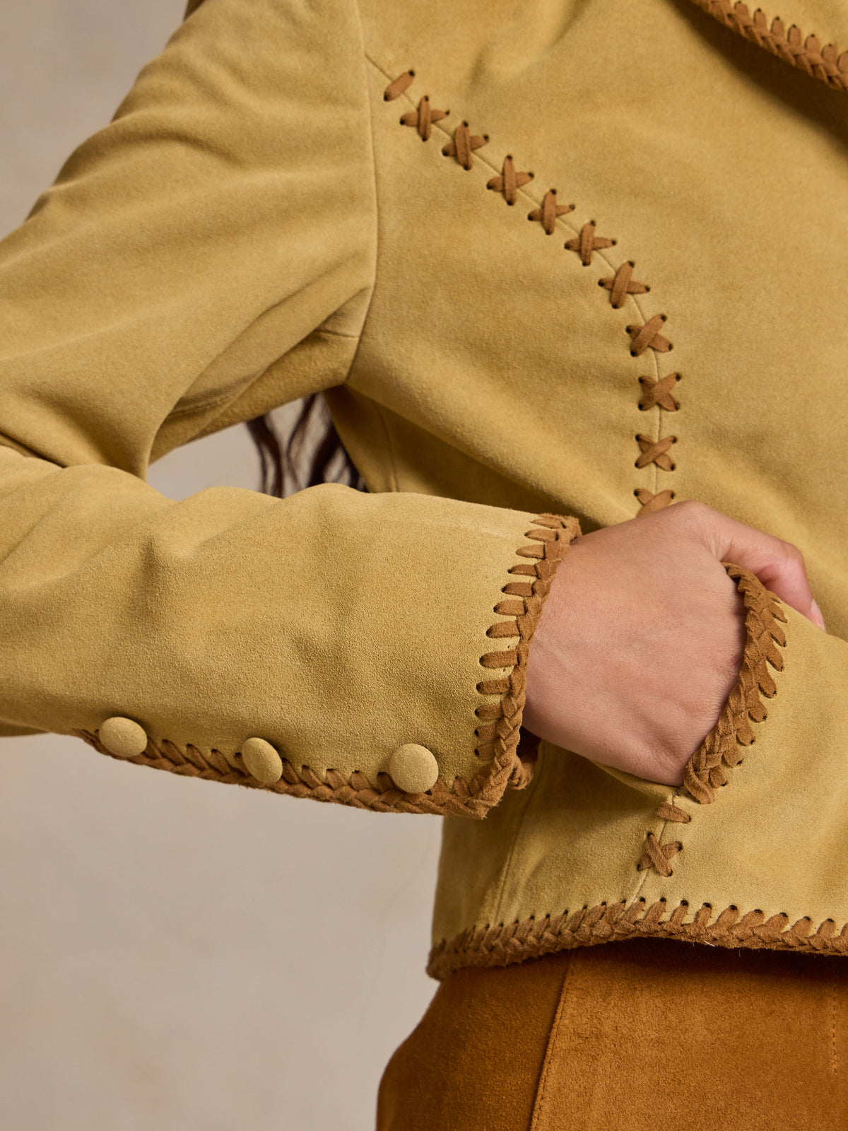 Buttercream suede jacket sleeve with whipstitch hem and cuff button detail