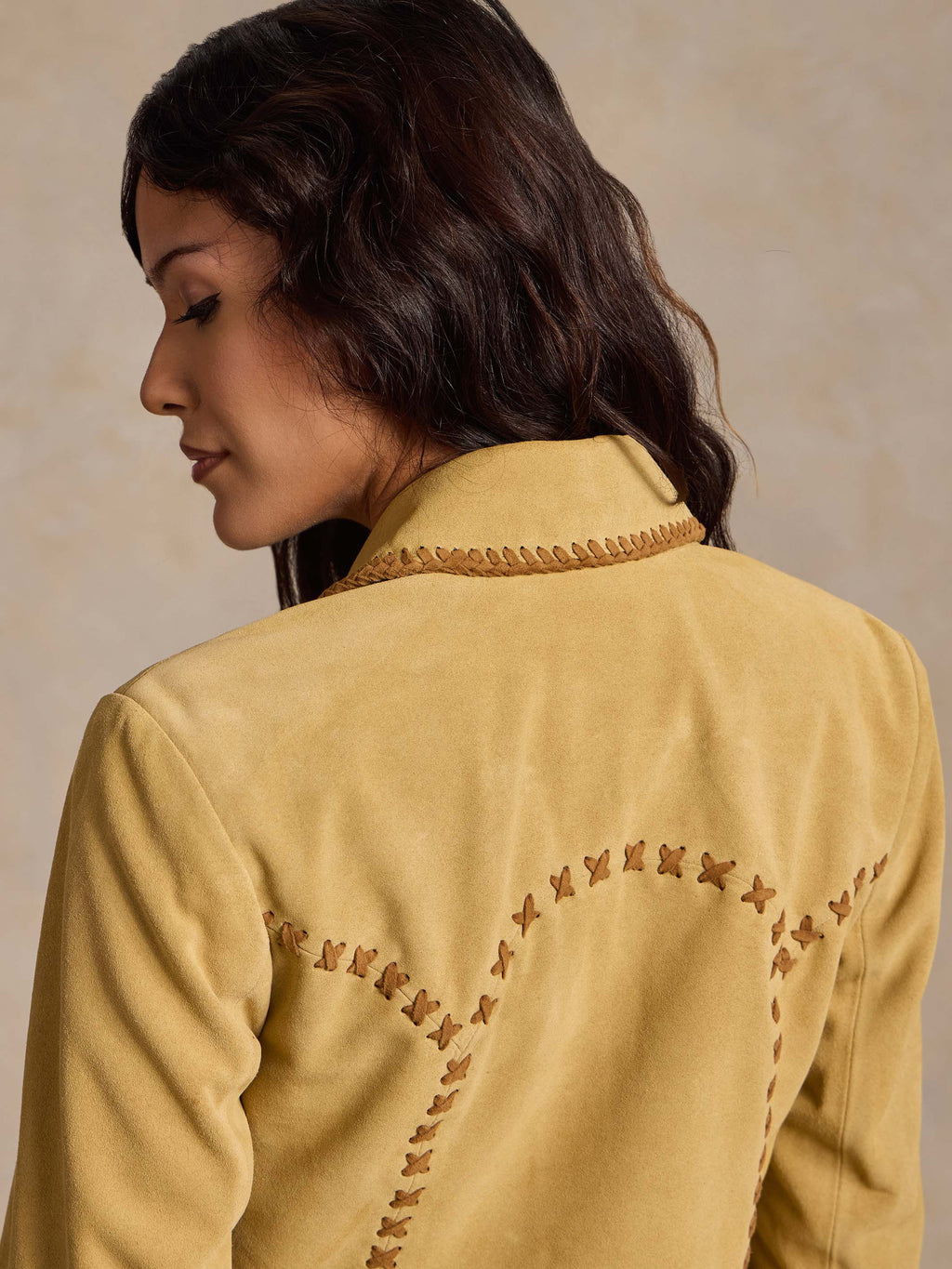 Buttercream suede jacket back with curved whipstitch embroidery and contrast trim