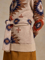 Belted knit sweater close-up with geometric motifs and tie at waist